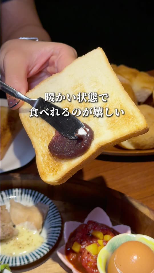 網で焼いたパンに具材をのせる様子