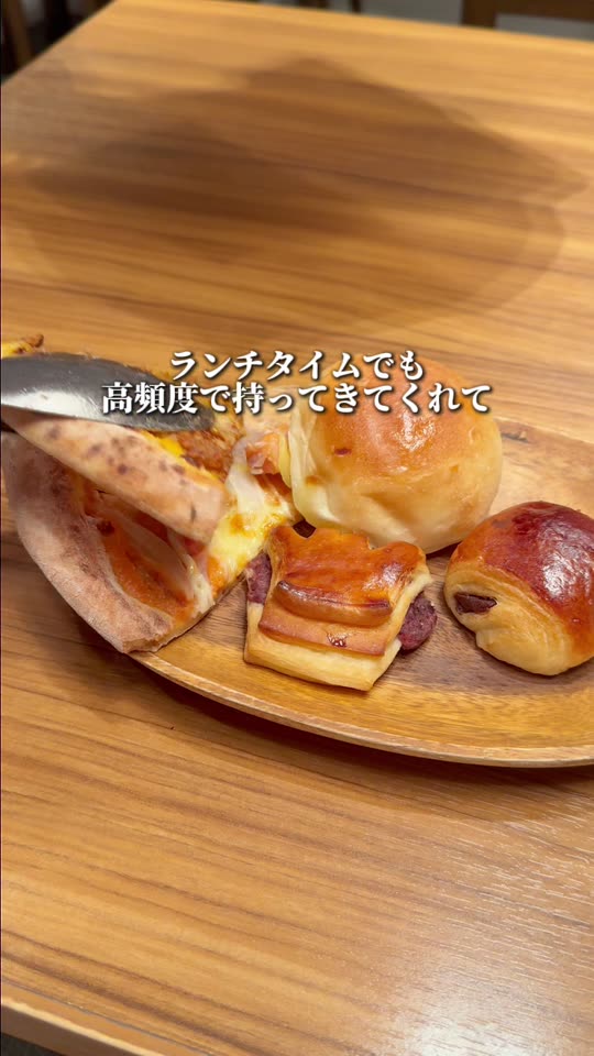 パンとピザが並ぶ木の皿