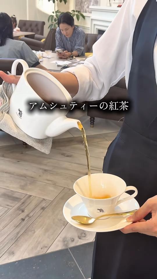 スタッフがポットで紅茶を注ぐ