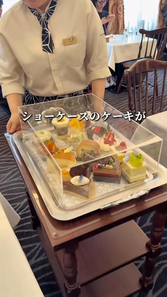 ガラスカバーのワゴンでケーキを運ぶ