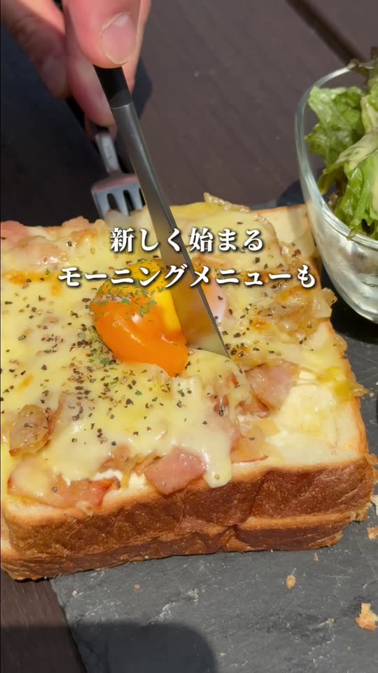 卵とチーズの厚切りトーストにナイフを入れる様子